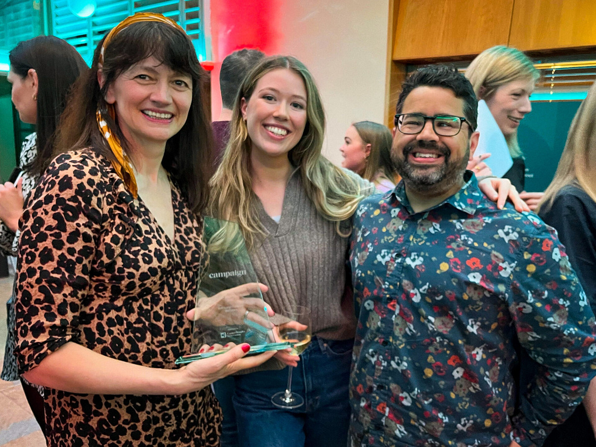 Jenny Biggam, Phoebe Lynch and Liam Mullins smiling and holding the Campaign Best Places to Work (Large Companies) award.